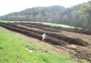 person monitoring compost windrow