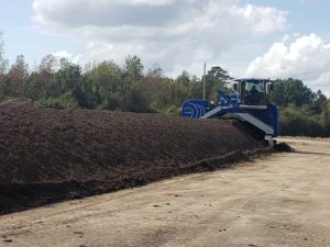 Compost windrow and the equipment used for turning (row turner)